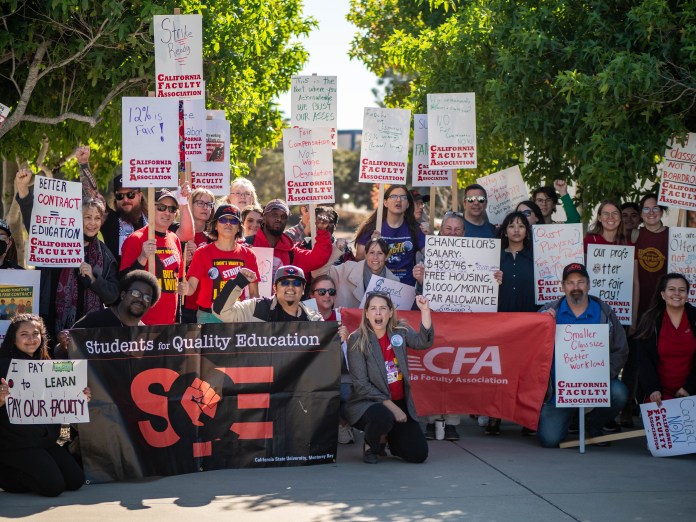 Group of people at a California Faculty Association strike walk. Large group of students and faculty posing for photo with signs.