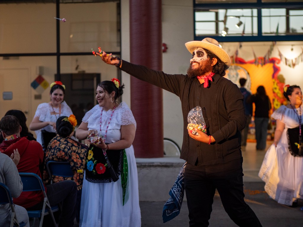 Folklorico dancer tossing candy out to the crowd.
