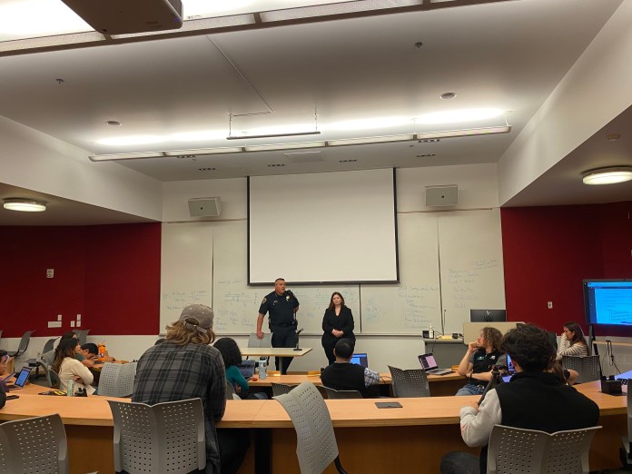 Photo of two people standing at the front of a lecture hall.