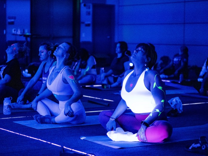 People doing yoga with glow in the dark clothing.