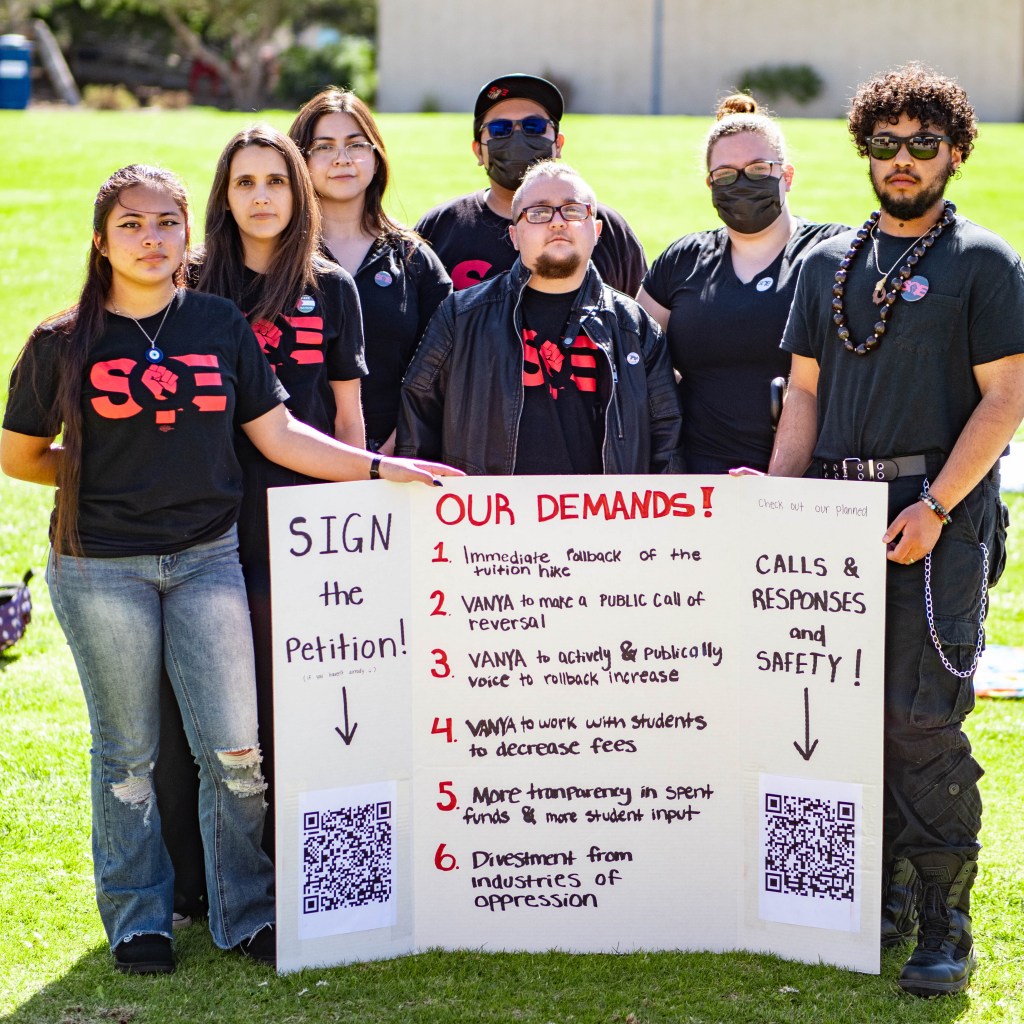 Students for Quality Education standing with a poster of their demands. 
