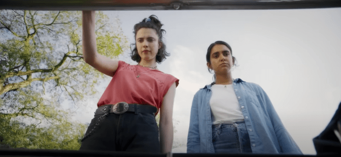 Two people looking into a car trunk.