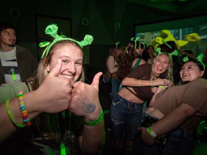 Students wearing ogre ears at the Swap Rave. Student in the front giving two thumbs up.