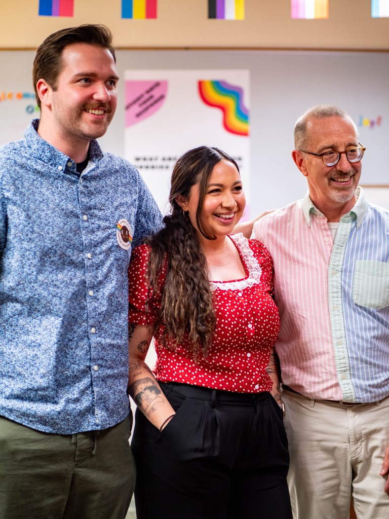 Three CSUMB staff members smiling for photo in the pride center.