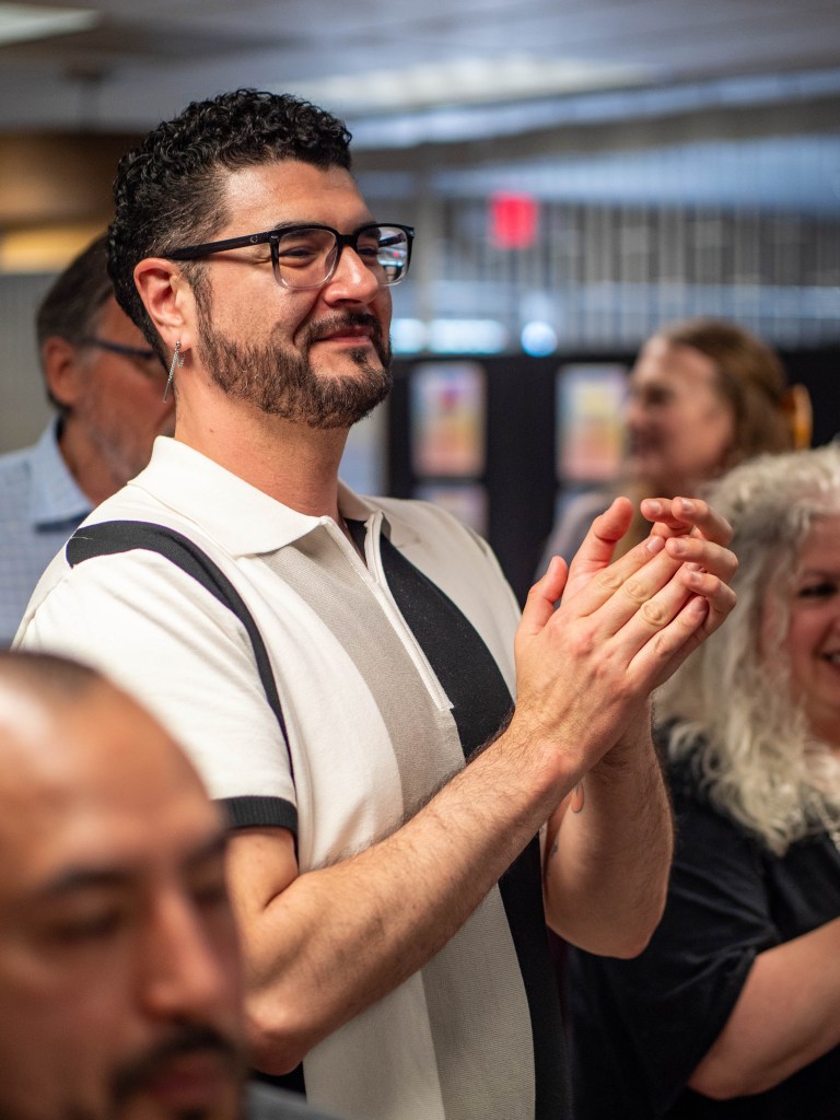 Attendee smiling and clapping.