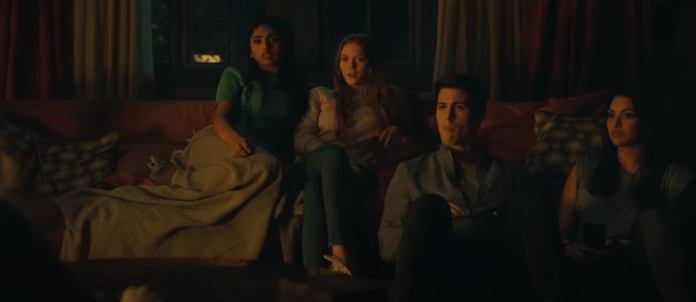 Four movie characters sitting together in a dim room.