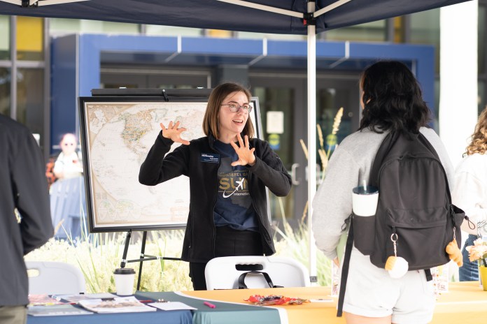 Photo of Event staff Nicole Newton talking to a event attendee.