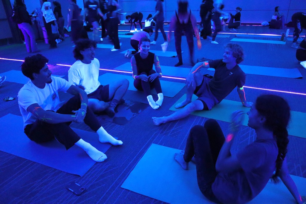 Image of multiple students sitting on the floor socializing