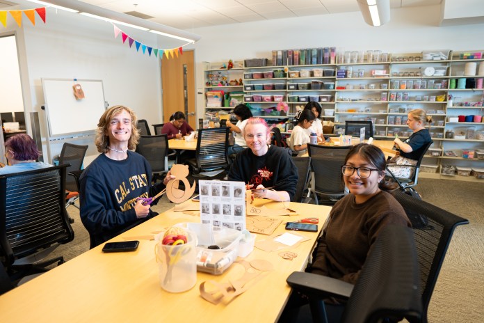 image of people at the makerspace posing for a photo while making lanterns.