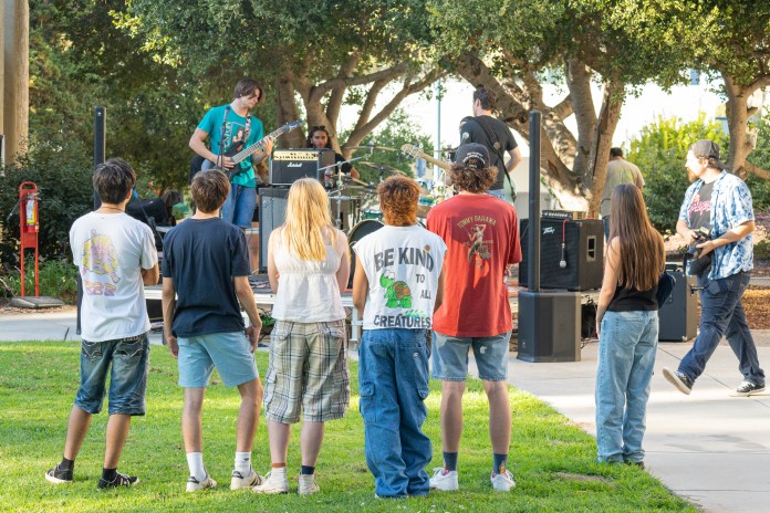 Picture of people crowning around a band while they play.