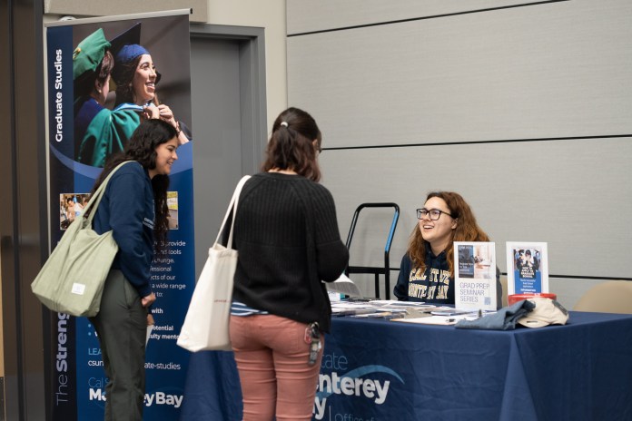 Picture of two students talking to a booth and asking questions