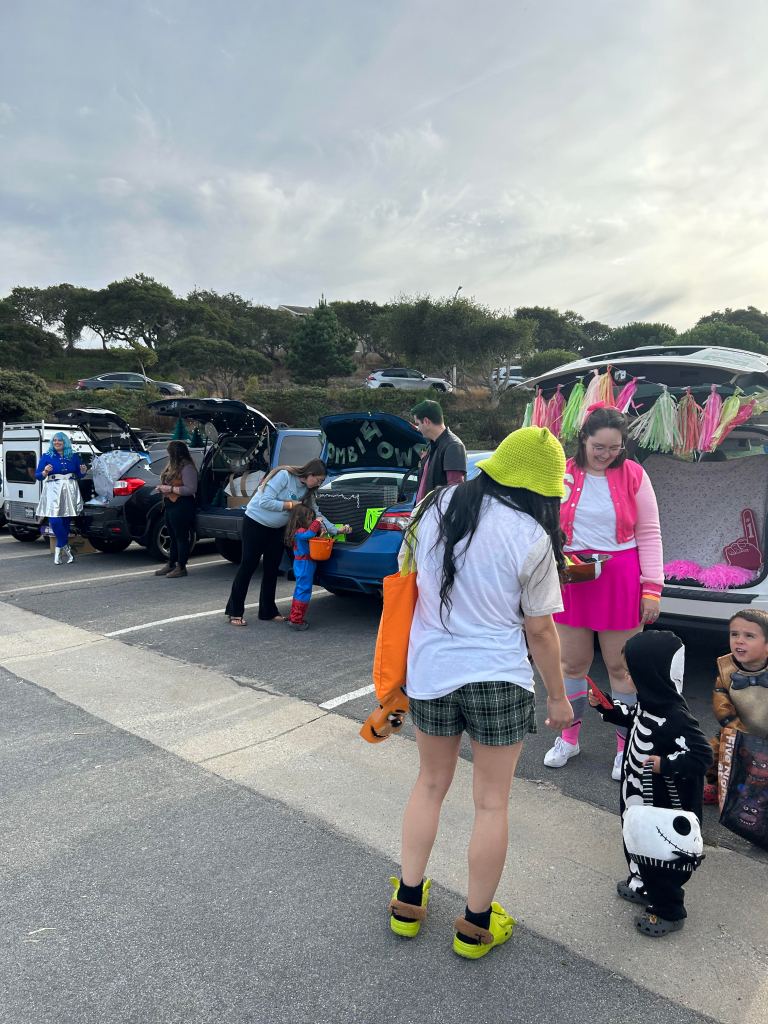 picture of 4 trunks open with kids going around gathering candy from them for trunk or treat