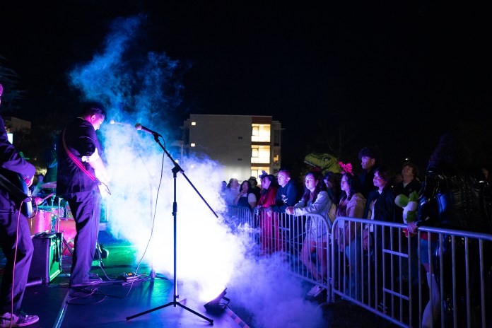Photo of a guitarist performing in front of a crowd.