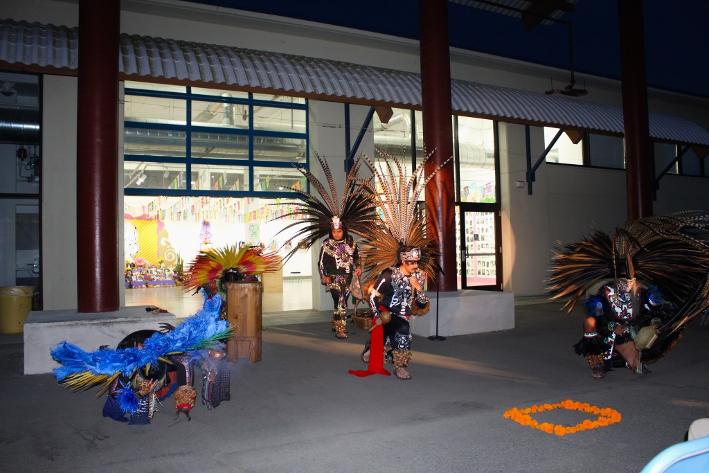 Photos of the Aztec dance group mid performance