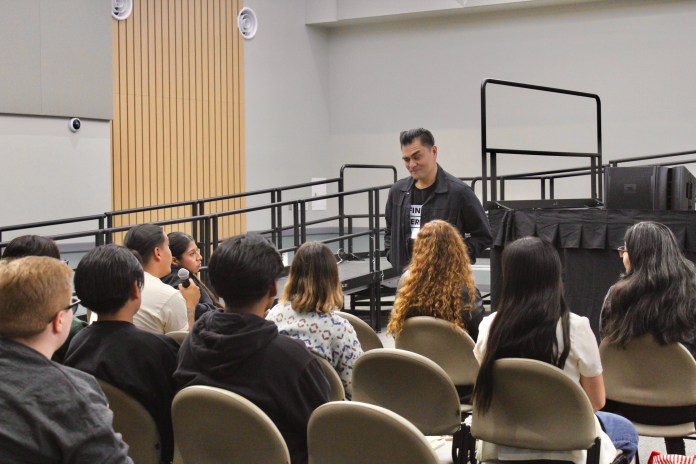 Picture of guest speaker Jose Antonio Vargas speaking with students and other event attendees