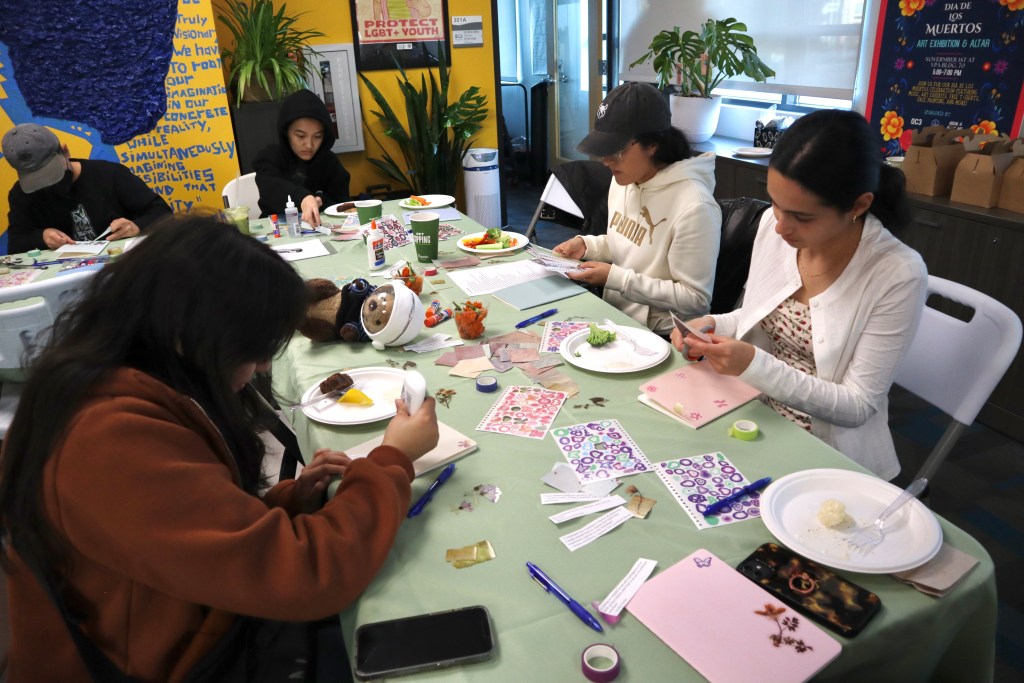 students sitting at a table doing arts and crafts