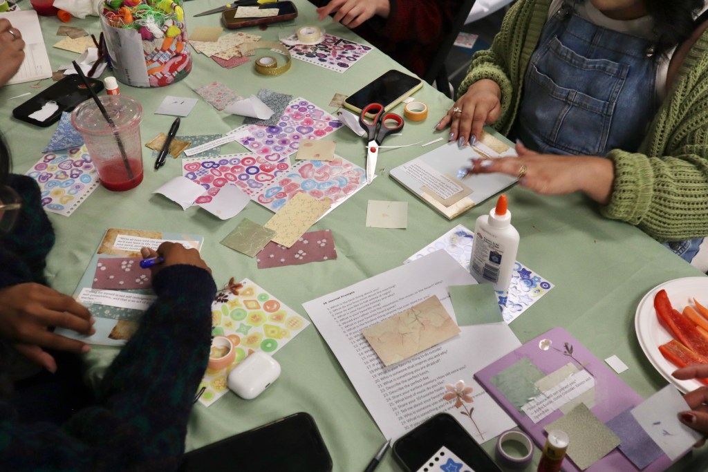 students sitting at a table doing arts and crafts