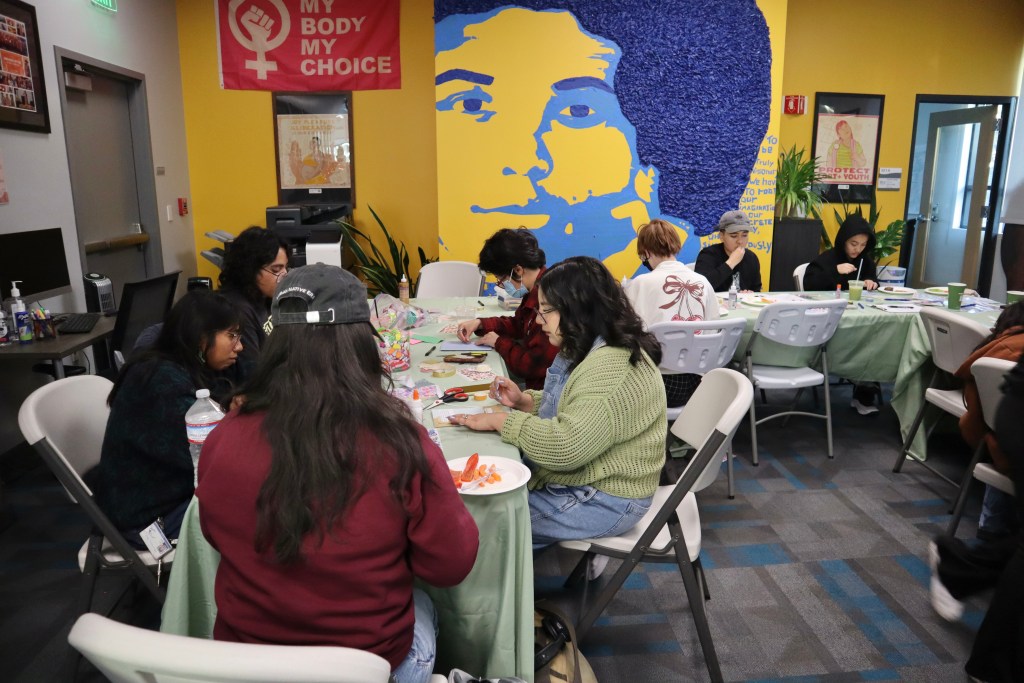 students sitting at a table doing arts and crafts