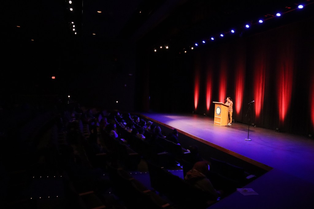 Photo of a writer speaking at a podium to an audience