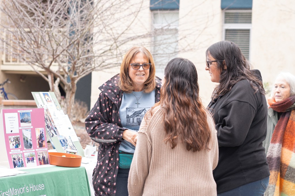 Picture of an event worker speaking with 2 attendees